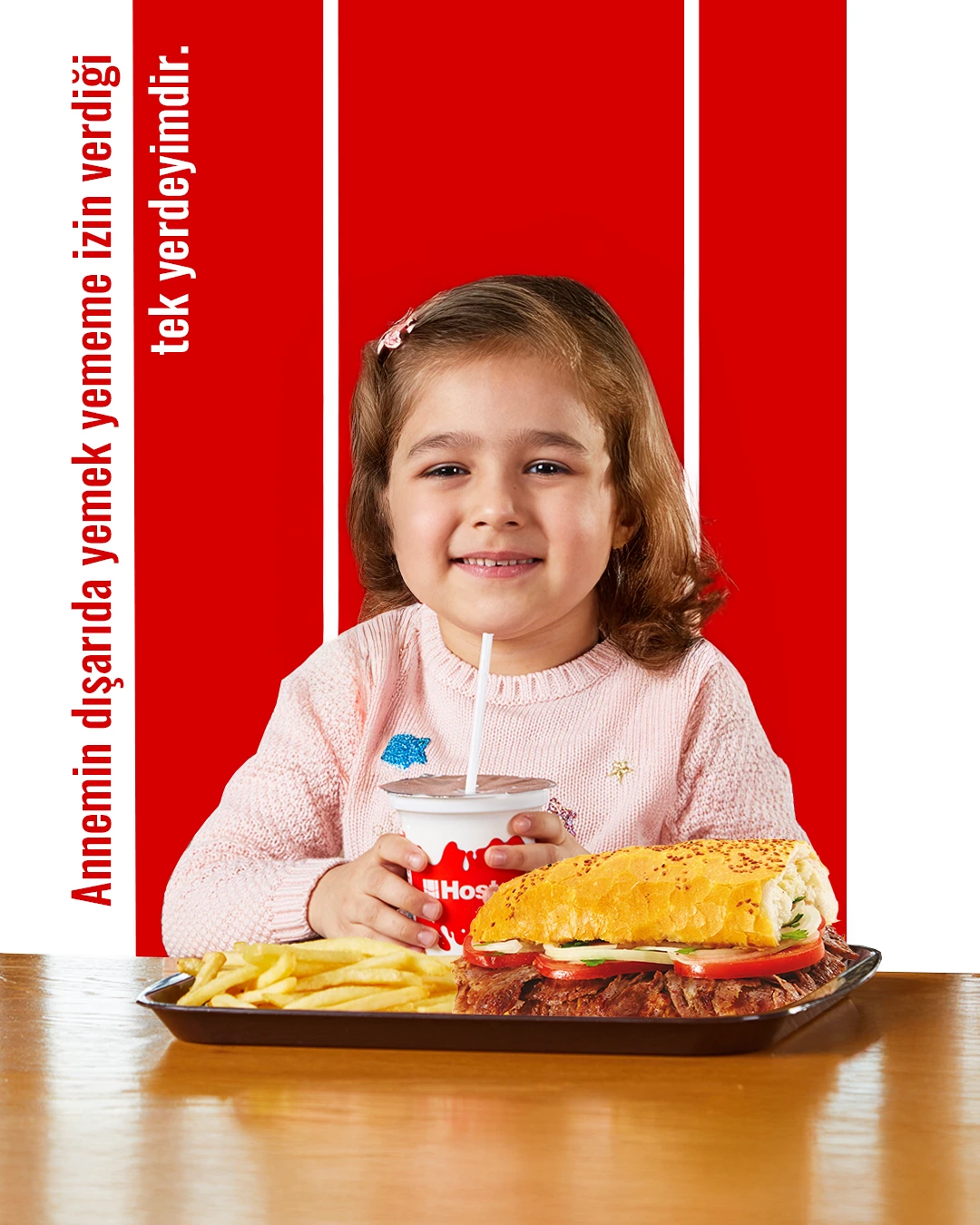 Mutlu bir çocuğun önündeki Hosta yaprak döner menüsüyle poz verdiği, üzerinde “Annemin dışarıda yemek yememe izin verdiği tek yerdeyimdir.” yazısı bulunan görsel.